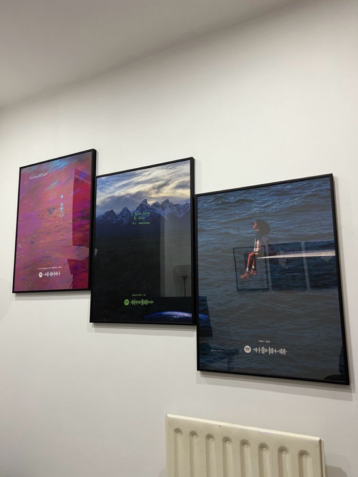 Three dark music plaques arranged as a gallery wall in a minimal interior